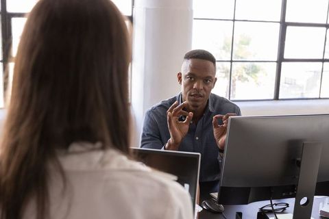 Diverse Team Engaging in Project Discussion at Office Desk