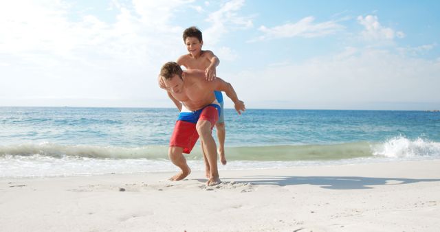 Father piggy-backing his son on the beach
