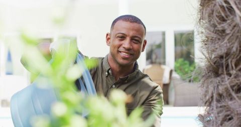 Smiling Man Watering Garden with Joyful Expression