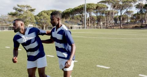 Rugby players practicing on sunny field