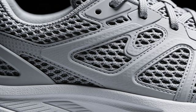 Grey breathable running sneaker closeup showcasing mesh texture and synthetic overlays