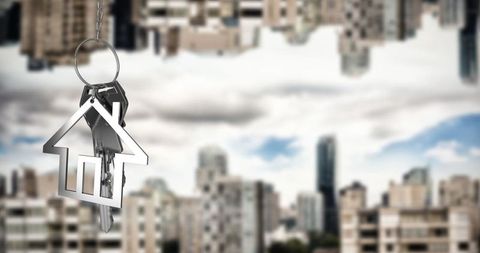 Metal House Keyring Hanging in Front of Cityscape Background