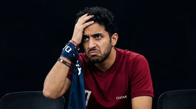 Frustrated qatari football fan holding head and scarf on bench showing disappointment