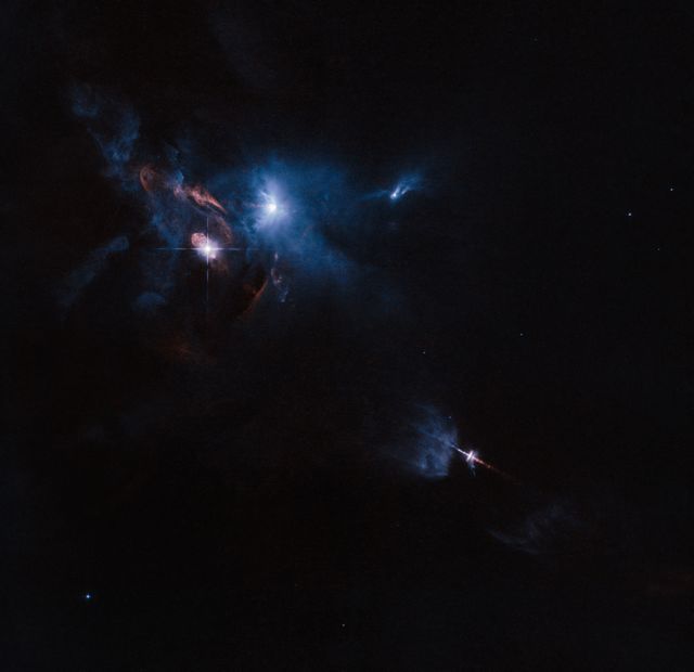 Stunning view of multiple star system XZ Tauri, its neighbor HL Tauri, and nearby stellar objects. Captured by Hubble Space Telescope, XZ Tauri emits a hot gas bubble with bright clumps and strong jets, creating a dramatic scene. Useful for educational materials, space science articles, and astronomy presentations. Suitable for illustrating concepts of star formation and interstellar dynamics.