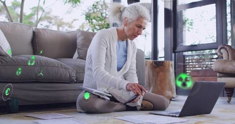 Mature woman working from home with laptop and documents surrounded by ar finance icons