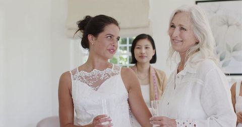 Bride Smiling with Friends in Bridal Suite During Wedding Preparation