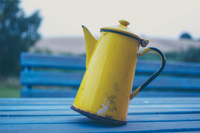 Yellow Ceramic Pitcher on Blue Surface - Download Free Stock Photos Pikwizard.com