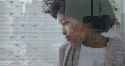 Gazing boy reflecting urban skyline through window, contemplative home portrait