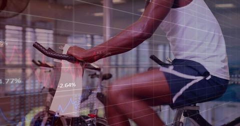 Fit man pedaling on indoor spin bike with data and performance graphs overlay
