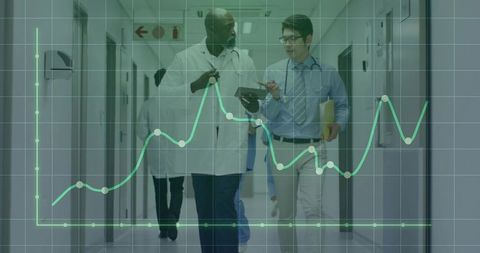 Doctors Collaborate in Hospital Corridor Analyzing Data Trends
