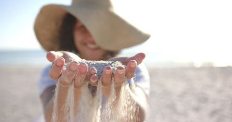 Woman Relaxing and Holding Sand at Sunny Beach - Download Free Stock Images Pikwizard.com