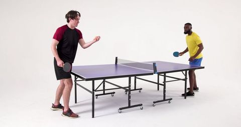 Diverse Friends Engaged in Table Tennis Match in Studio