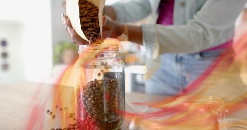 Woman Storing Coffee Beans in Glass for Freshness and Aroma