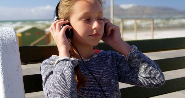 Girl Enjoying Music on Bench by Sunny Seaside Promenade - Download Free Stock Images Pikwizard.com