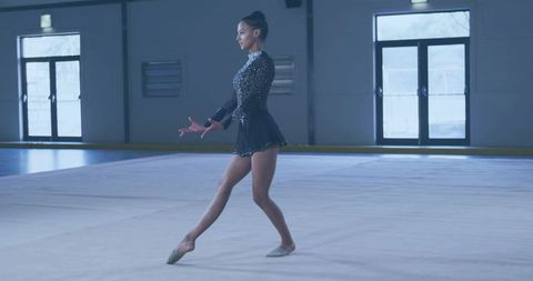 Graceful Rhythm Gymnast Performing Exercise in Gymnasium