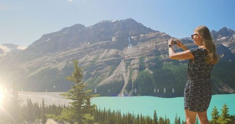 Woman Capturing Mountain Views on Smartphone in Sunny Day - Download Free Stock Images Pikwizard.com