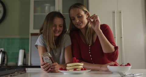 Mother and Daughter Making Pancakes with Fresh Raspberries