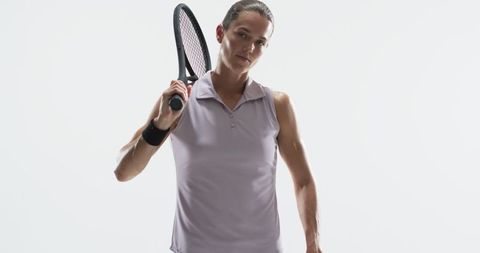 Focused female tennis player holding racket indoors