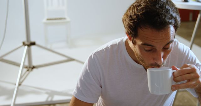 Man Drinking Coffee in Minimalistic Studio - Download Free Stock Images Pikwizard.com