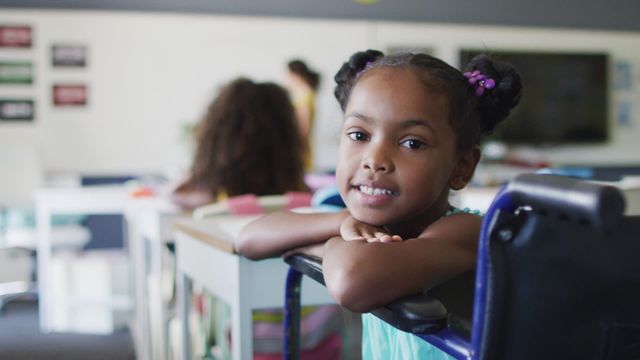 Young Black girl in colorful classroom environment cheerfully embracing her education despite disability. Demonstrates empowerment, inclusion, and determination in educational settings. Effective for educational content, disability awareness, diversity inclusion promotions, and inspiring youth.