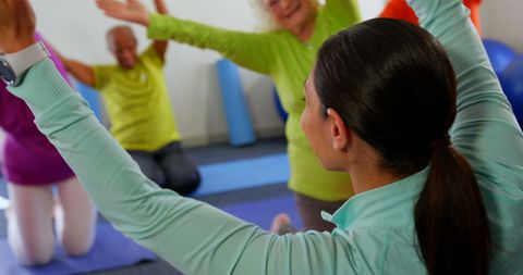 Female Trainer Leading Seniors in Group Fitness Exercise