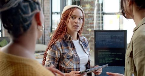 Diverse Team Collaborating Around Tablet in Modern Workspace