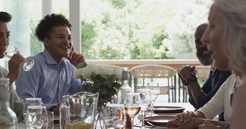Friends sharing laughter during wedding reception at elegant table