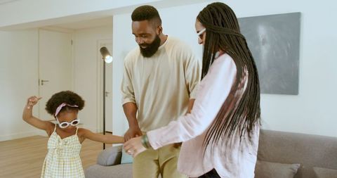 Happy Family Dancing in Living Room Celebrating Together