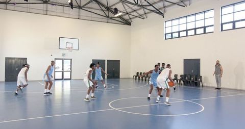 Male Basketball Players Dribbling Toward Court Hoop