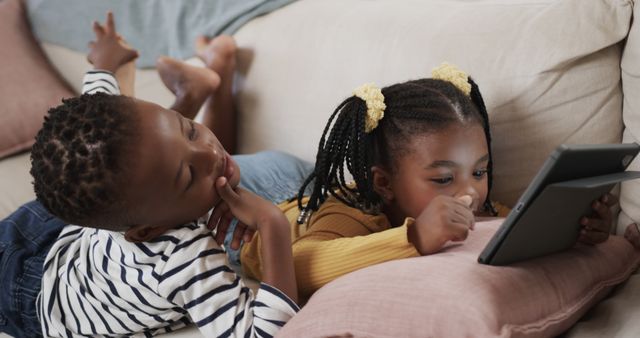 Two Children Relaxing on Couch with Digital Tablet - Download Free Stock Images Pikwizard.com