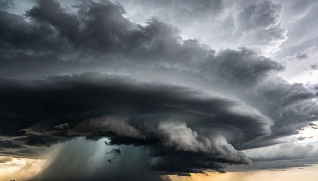 Massive rotating supercell thunderstorm displaying shelf cloud and intense rain shaft