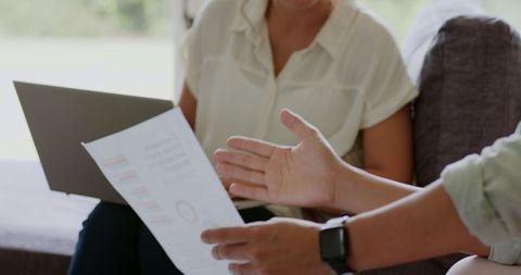 Couple planning wedding details together using laptop at home