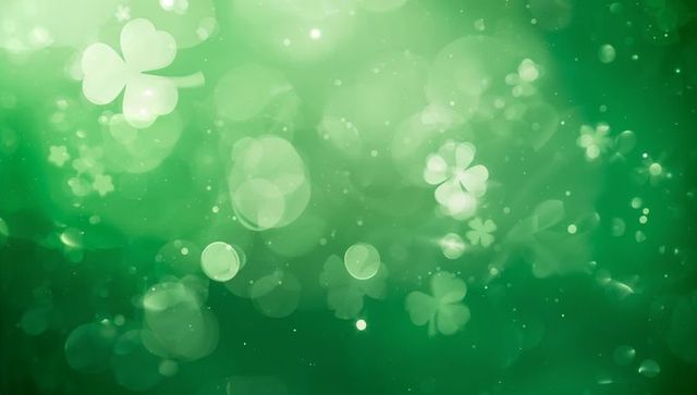 Emerald shamrock bokeh background with floating clover lights and sparkling orbs