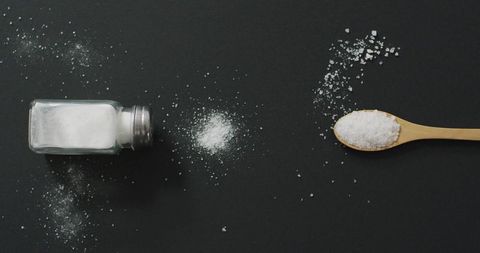 Salt Shaker and Spoon on Black Background for Cooking