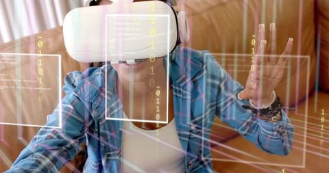Woman in plaid shirt wearing VR headset interacting with holographic interface on sofa