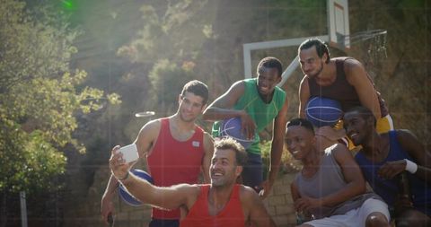 Diverse Basketball Team Celebrating and Photographing Outdoor Court Moment