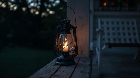 Vintage oil lantern on porch creating rustic ambience at dusk