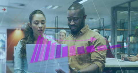 Diverse Colleagues Analyzing Data on Laptop with Stock Market Graphics