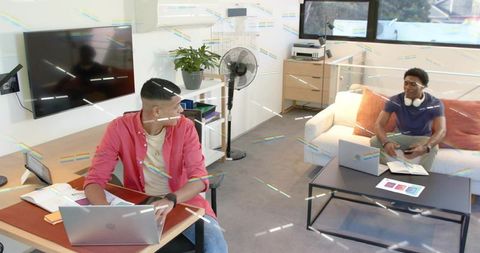 Collaborating remotely in modern home office living room with laptops and casual teamwork