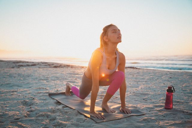 Caucasian woman exercising outdoors practicing yoga on beach at sunset - Download Free Stock Photos Pikwizard.com