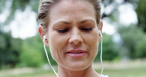 Joyful Female Runner Enjoying Music with Earbuds in Park - Download Free Stock Images Pikwizard.com