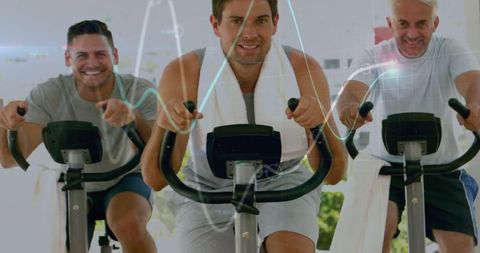 Men engaging in vigorous spin class at modern gym