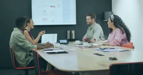 Diverse team brainstorming in modern office with technology display