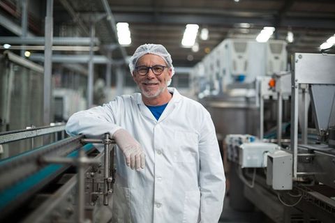 Senior technician smiling in modern food processing facility