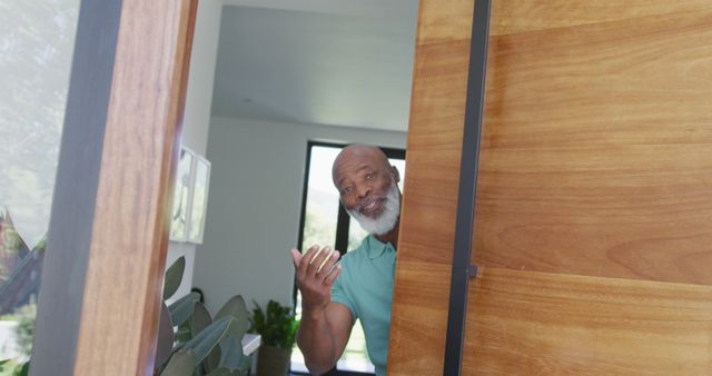 Portrait of happy senior african american man opening door at retirement home. healthy, active retirement and body inclusivity.