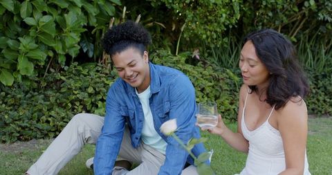 Couple Having Picnic in Lush Garden On Sunny Day