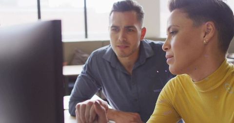 Focused Coworkers Collaborating on Computer Analysis in Office