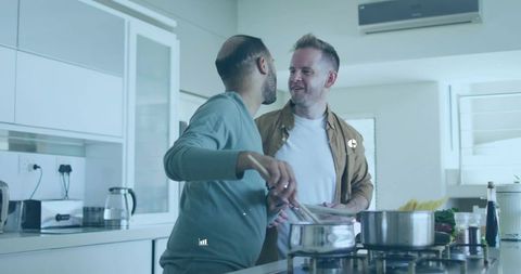 Two men cooking together in bright modern kitchen sharing intimate meal-prep moment