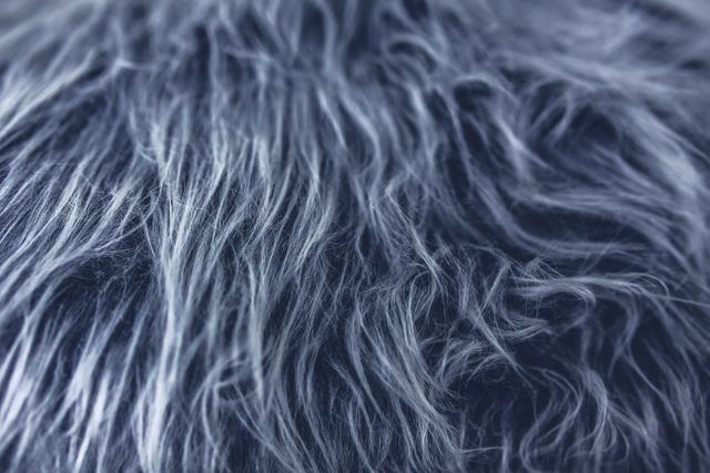 Dark fluffy fur texture close-up with soft and feathery appearance. Ideal for use as a background, in design projects, or in articles about tactile materials.