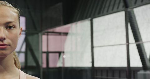 Confident young woman ready for padel match on indoor court